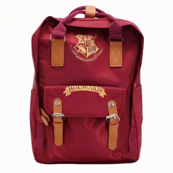 Roter Schulranzen-Rucksack in rechteckiger Form, wobei die Höhe länger als die Breite ist. Braune Riemen und ein brauner Griff. Ein Logo im Wappenstil und ein Schriftzug auf der unteren Tasche in gelb.