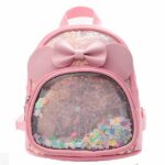 Kleiner Mädchen-Rucksack mit rosa Schleife und weißem Hintergrund