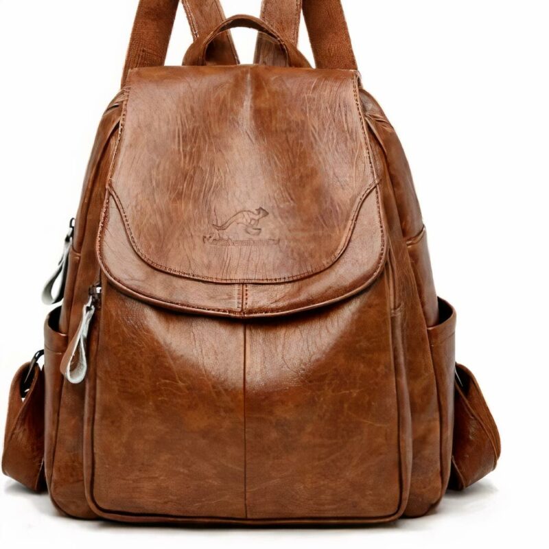 Tasche aus Kunstleder von Schafen. Die Tasche ist von hellbrauner Farbe. Sie hat zwei kleine Seitentaschen. Eine große Tasche in der Mitte und eine kleinere Tasche in der Mitte. Die Tasche hat einen Henkel, um sie an einem Haken zu befestigen, und zwei Henkel, um sie auf dem Rücken zu tragen.