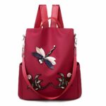 Bestickter Rucksack mit Blumen- und Schmetterlingsmotiv für Frauen in Rot mit weißem Hintergrund