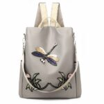 Bestickter Rucksack mit Blumen- und Schmetterlingsmotiv für Frauen in Beige und Grau mit weißem Hintergrund