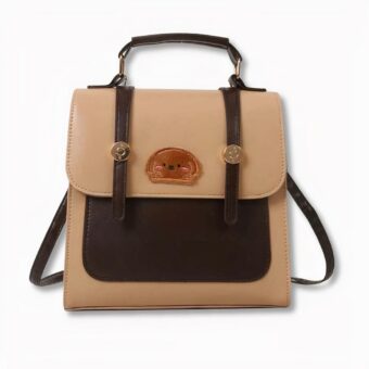 Brauner und beiger Schulrucksack mit einem Hundegesichtsabzeichen auf der Vorderseite, auf hellgrauem Hintergrund