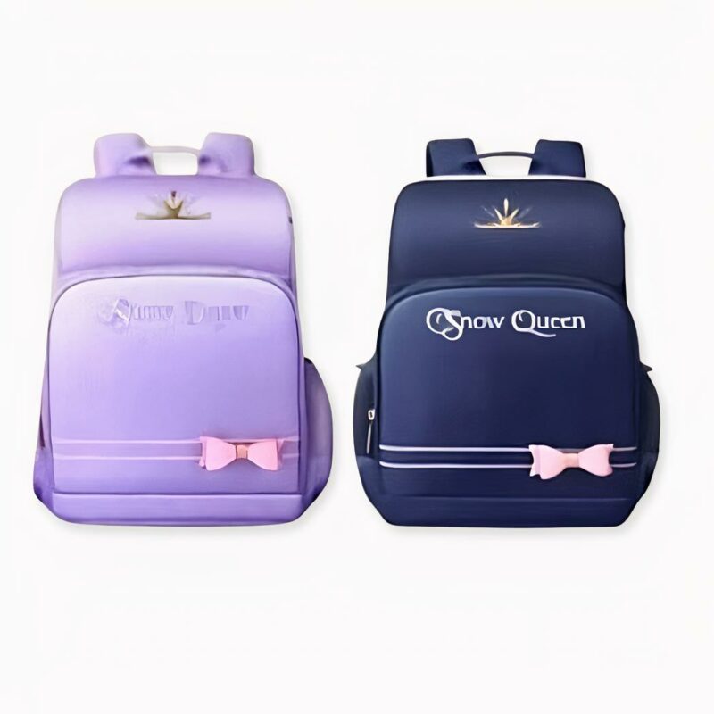 Sac_à_dos_Reine_des_Neiges_avec_nœud_pour_enfant_2 2 dunkelblaue und lilafarbene Rucksäcke mit dem Schriftzug snow queen und mit einer kleinen rosa Schleife auf der Vorderseite
